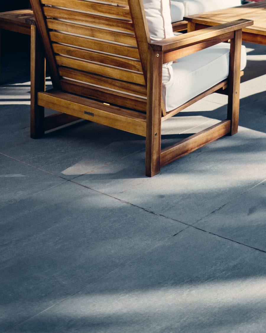 Fertige Terrasse mit Holzmöbeln auf großformatigen Platten